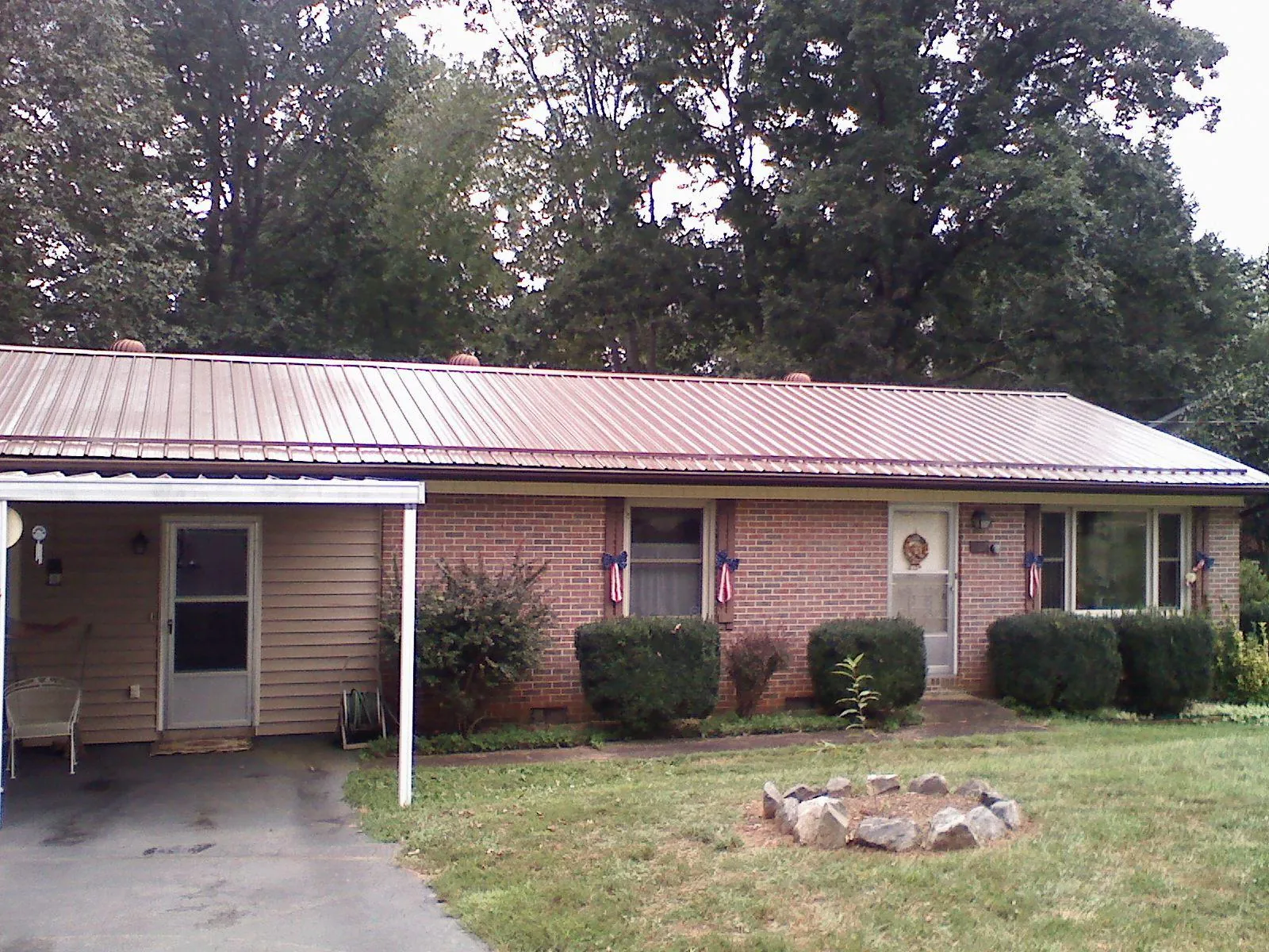 Bronze metal roof and carport on a brick ranch home — Roof Repair work by our crew in Greenfield
